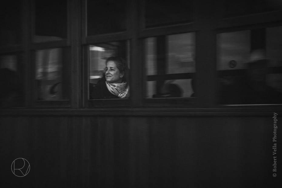 A woman looking out through a window, seen from the street